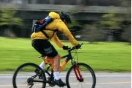 person in yellow jacket riding bycicle