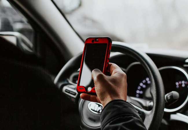 Person texting while driving, distracted driving accident lawyer